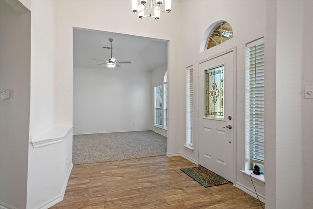 entryway with ceiling fan with notable chandelier and light hardwood / wood-style flooring