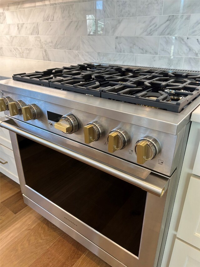 room details with gray cabinets, light stone countertops, sink, and decorative backsplash