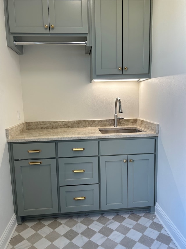 bar with a sink, baseboards, and light floors