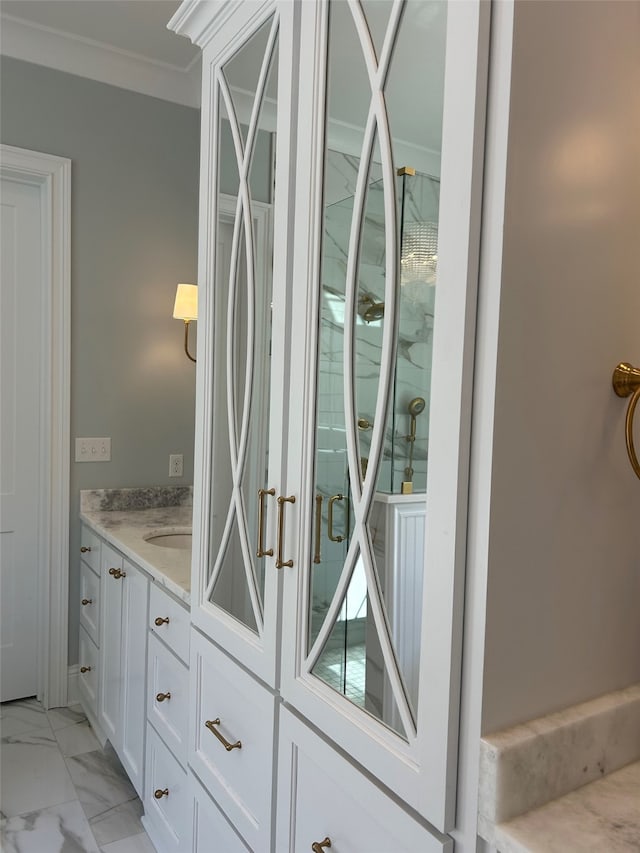 interior space featuring marble finish floor, ornamental molding, and vanity