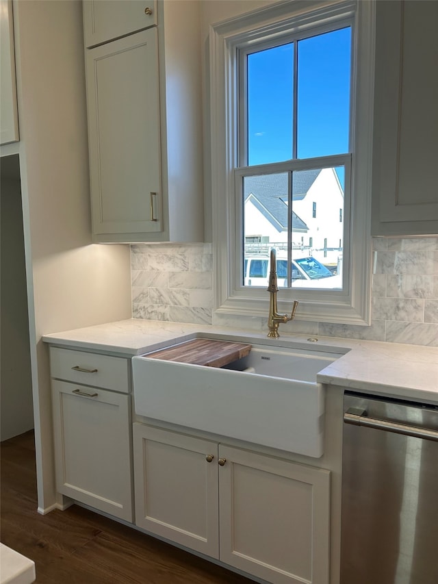 kitchen featuring a sink, tasteful backsplash, dishwasher, and dark wood finished floors