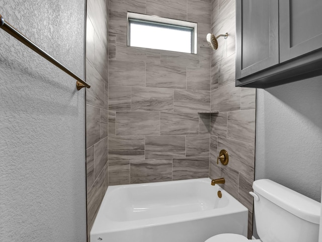 bathroom featuring tiled shower / bath and toilet