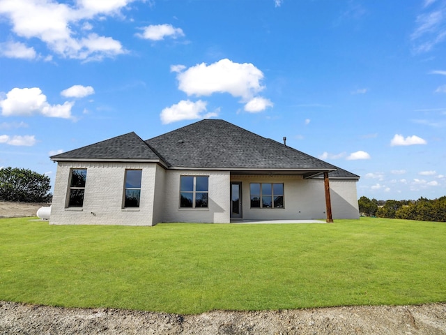 rear view of property featuring a lawn