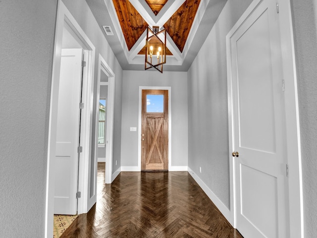 foyer entrance featuring dark parquet flooring and an inviting chandelier