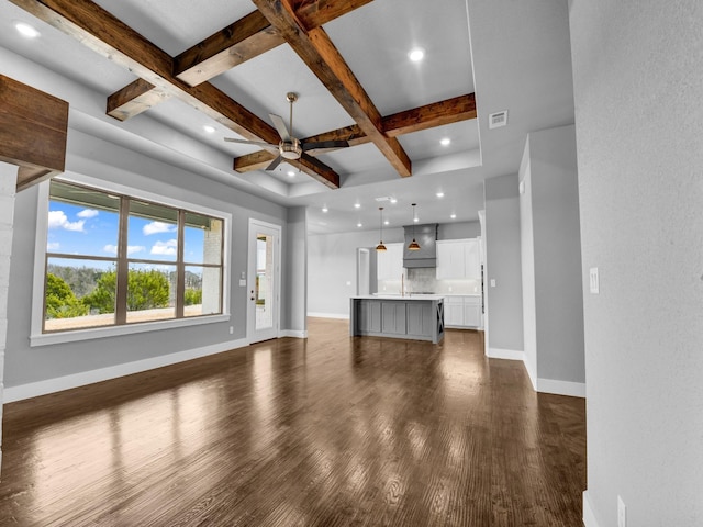 unfurnished living room with beamed ceiling, dark wood-type flooring, ceiling fan, and coffered ceiling