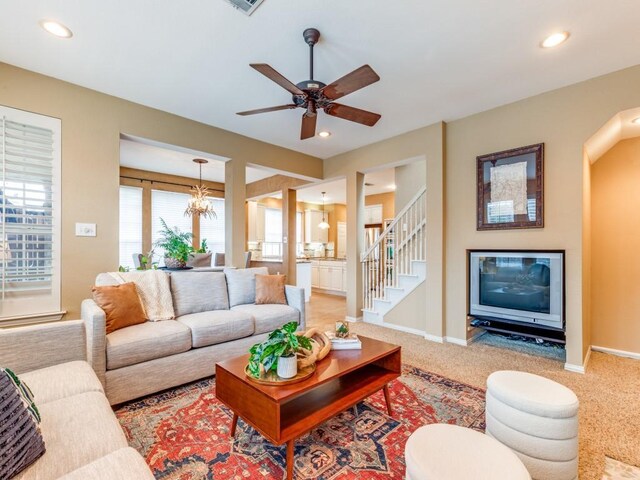 living room featuring a fireplace, built in shelves, ceiling fan, and a wealth of natural light