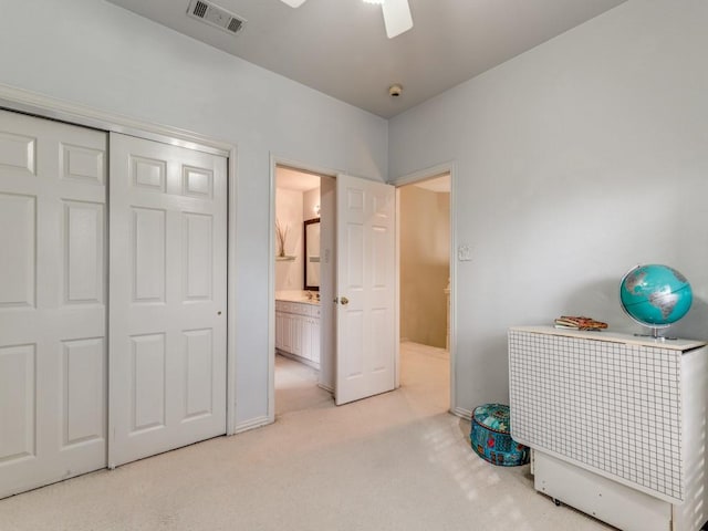 interior space featuring ceiling fan and light colored carpet