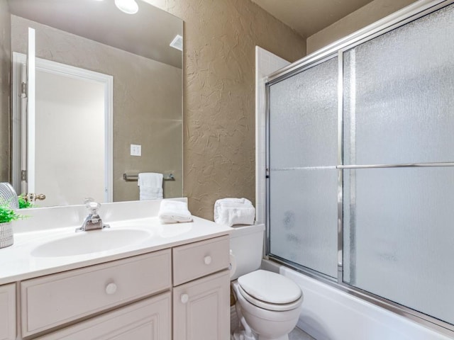 full bathroom featuring shower / bath combination with glass door, vanity, and toilet