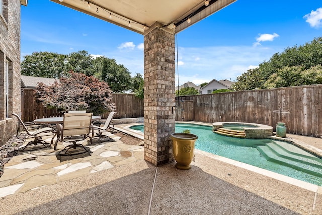 view of swimming pool featuring a patio and an in ground hot tub