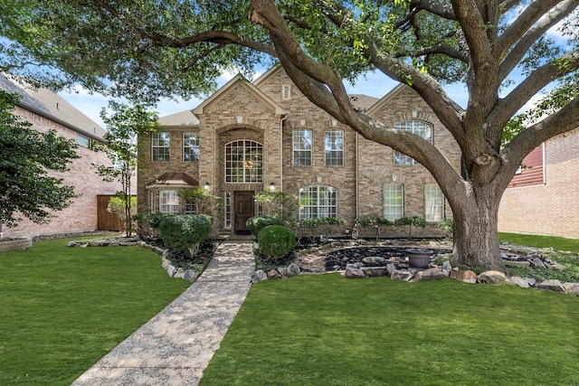 view of front of home featuring a front yard and brick siding