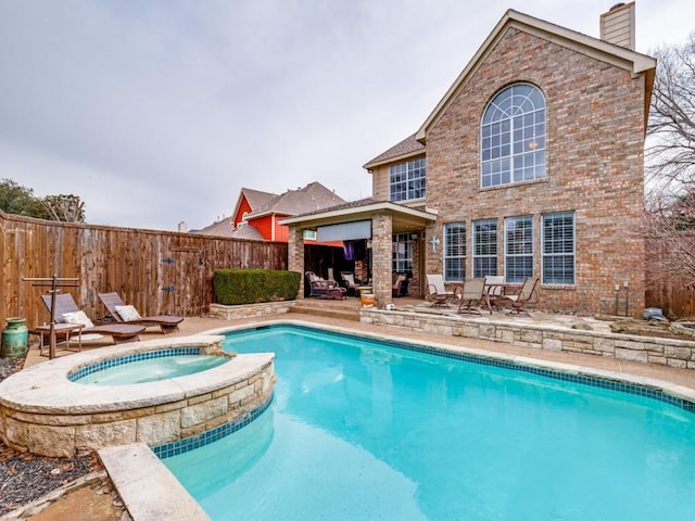 view of swimming pool featuring a patio area and an in ground hot tub