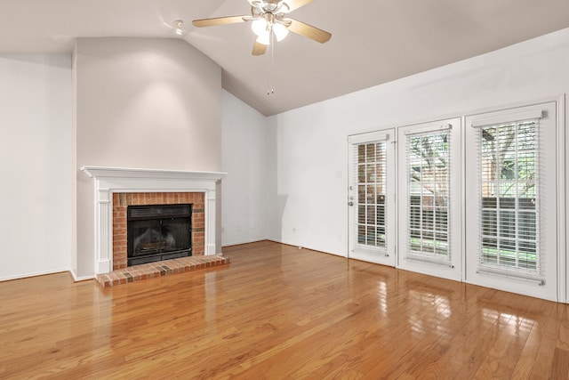 unfurnished living room featuring ceiling fan, hardwood / wood-style floors, lofted ceiling, and a brick fireplace