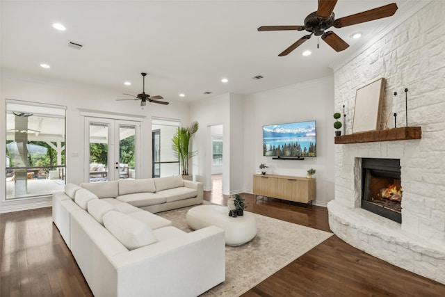 living room featuring a fireplace, french doors, ornamental molding, and dark wood-type flooring