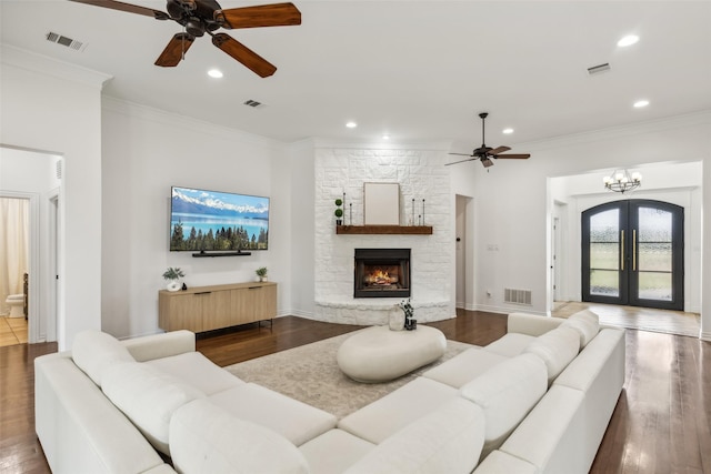 living room featuring french doors, dark wood-type flooring, and ornamental molding