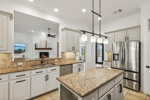 kitchen featuring ceiling fan, sink, stainless steel appliances, kitchen peninsula, and decorative light fixtures