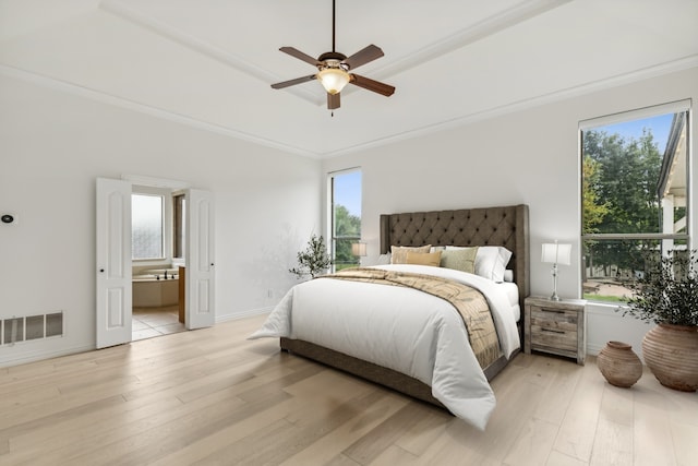 bedroom featuring ceiling fan, ornamental molding, light hardwood / wood-style flooring, and ensuite bath