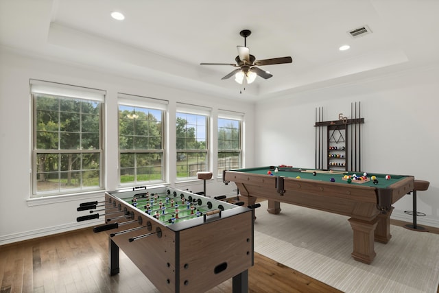 rec room with a raised ceiling, crown molding, billiards, hardwood / wood-style flooring, and ceiling fan