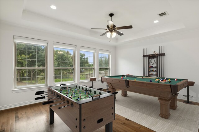 game room with hardwood / wood-style flooring, plenty of natural light, and a raised ceiling