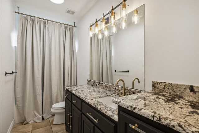 bathroom featuring vanity, toilet, and tile patterned flooring