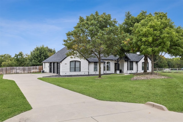 french country home featuring a garage and a front yard