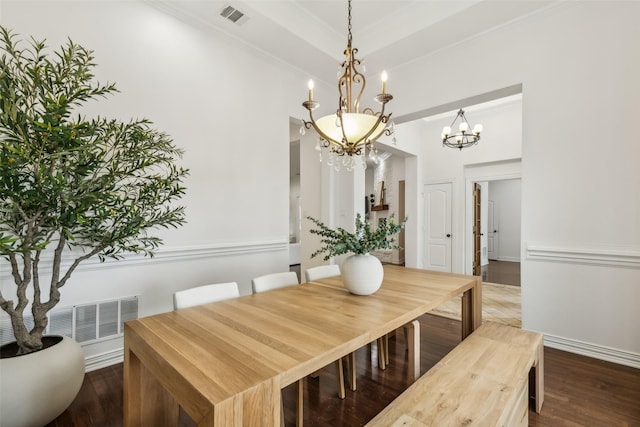 dining room featuring crown molding, dark hardwood / wood-style flooring, and a chandelier