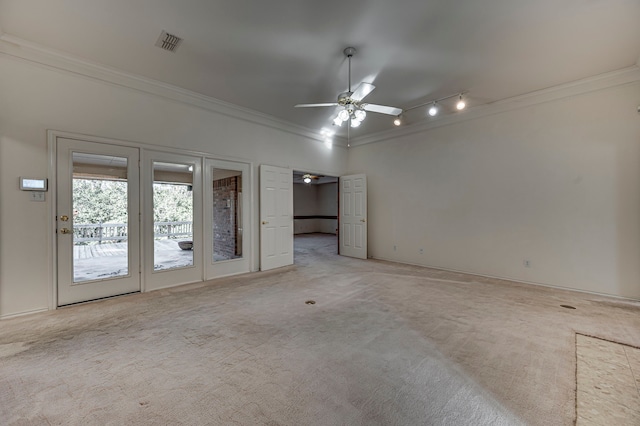 interior space with track lighting, ceiling fan, crown molding, and light colored carpet