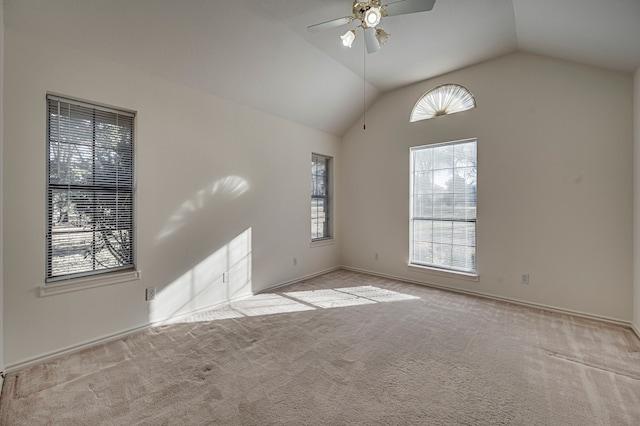 empty room with ceiling fan, a healthy amount of sunlight, vaulted ceiling, and light carpet