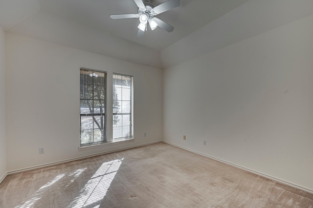 empty room with light colored carpet, ceiling fan, and lofted ceiling