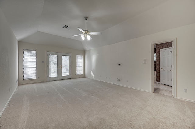 spare room featuring ceiling fan, lofted ceiling, light carpet, and french doors