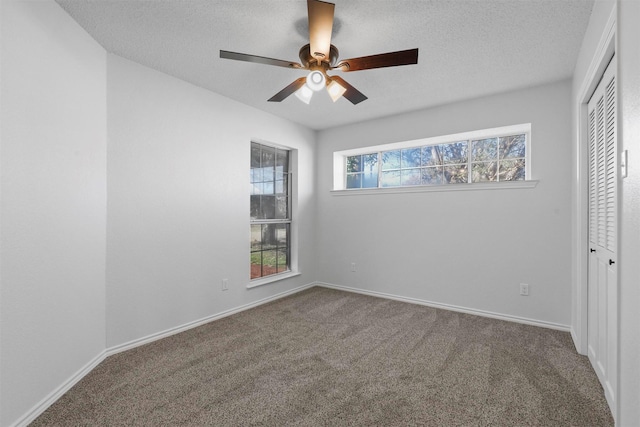 unfurnished bedroom with ceiling fan, carpet floors, a textured ceiling, and a closet