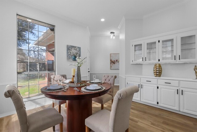 dining space featuring a wealth of natural light, wood-type flooring, and ornamental molding