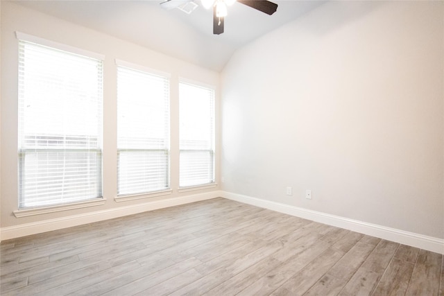 spare room with vaulted ceiling, ceiling fan, and light wood-type flooring