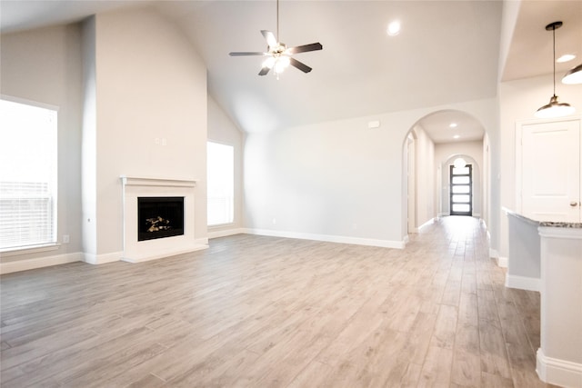 unfurnished living room featuring ceiling fan, high vaulted ceiling, and light hardwood / wood-style floors