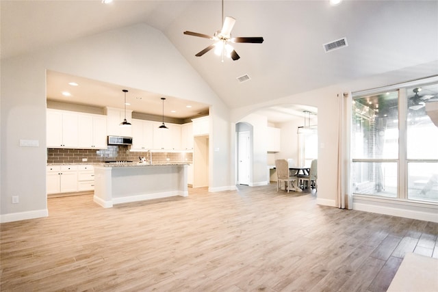 unfurnished living room featuring ceiling fan, high vaulted ceiling, and light hardwood / wood-style floors