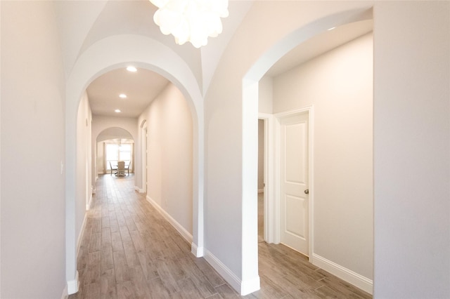 hall featuring a notable chandelier and light hardwood / wood-style flooring