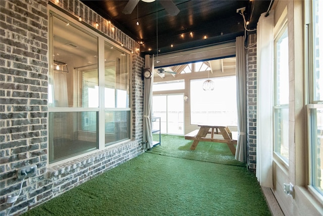 unfurnished sunroom with ceiling fan