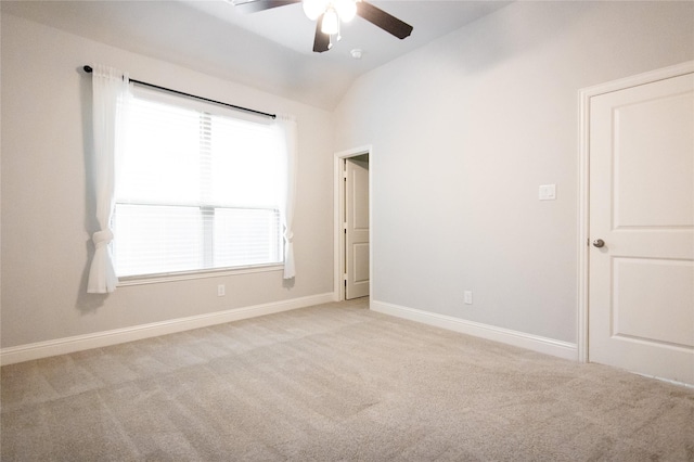 empty room featuring ceiling fan, lofted ceiling, and light carpet