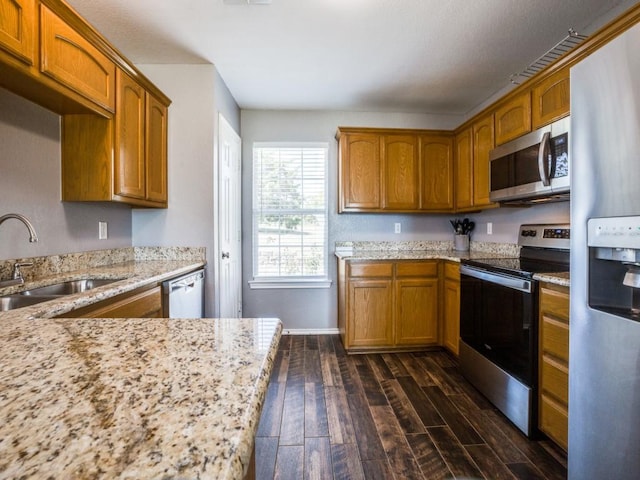 kitchen featuring dark hardwood / wood-style floors, sink, light stone countertops, and stainless steel appliances