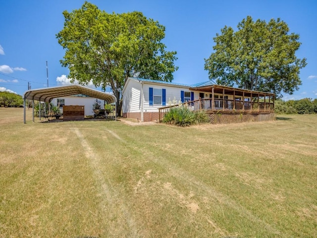 rear view of house featuring a yard and a carport