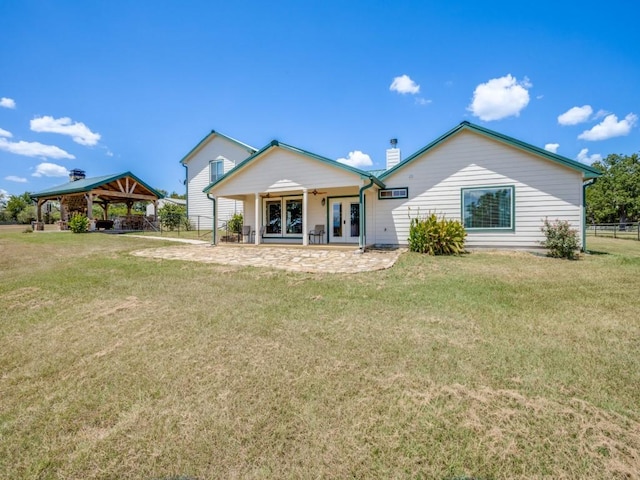 rear view of property with a gazebo, french doors, and a yard