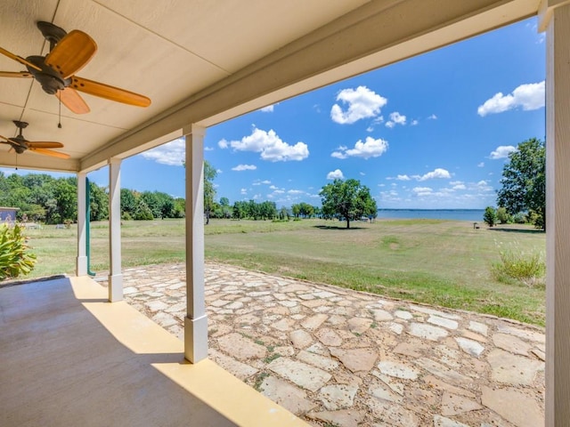 view of patio / terrace featuring a water view and ceiling fan