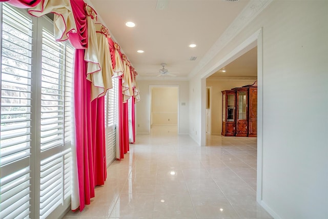 corridor featuring crown molding and light tile patterned flooring