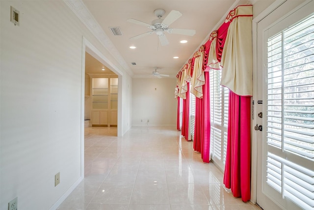 hall featuring ornamental molding and light tile patterned floors