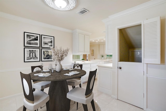 tiled dining space featuring crown molding