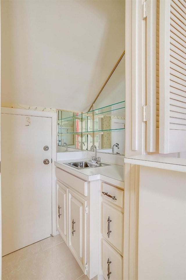 bar featuring sink, light tile patterned floors, and vaulted ceiling