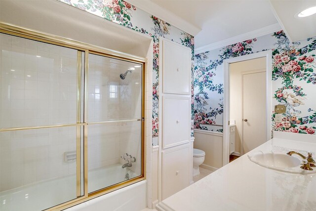 full bathroom featuring vanity, crown molding, shower / bath combination with glass door, and toilet