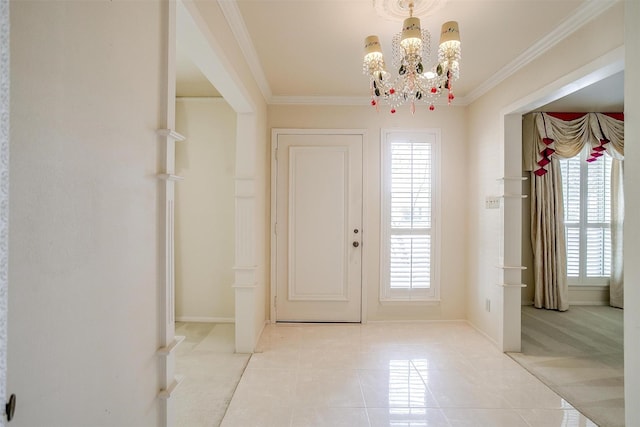 entryway with a notable chandelier, ornamental molding, a healthy amount of sunlight, and light tile patterned flooring