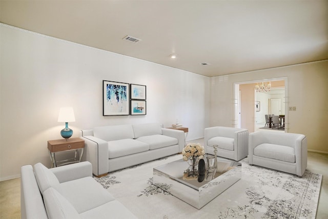 carpeted living room featuring a notable chandelier