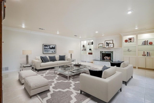 living room with ornamental molding, light tile patterned flooring, built in features, and a high end fireplace