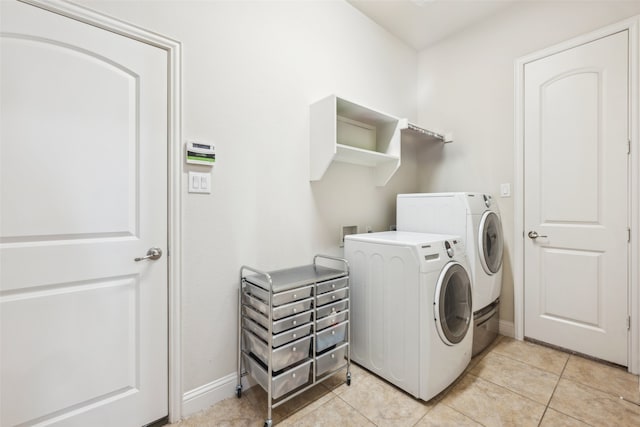 clothes washing area featuring washing machine and dryer and light tile patterned floors